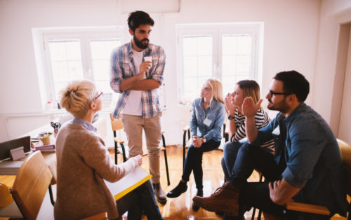 Young people in apparent group conversation with a peer.