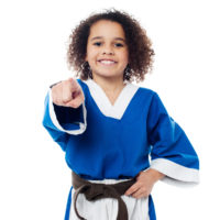 Cheerful karate kid pointing at viewer
