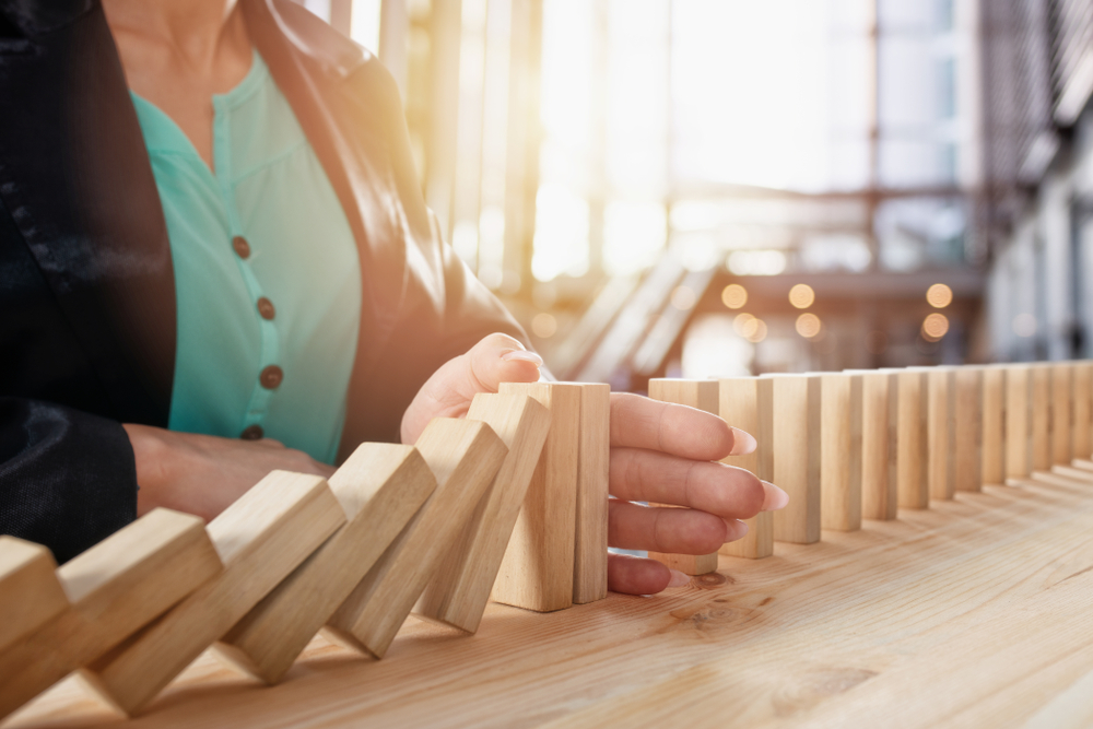 Hand stopping a chain of falling blocks (like dominos)