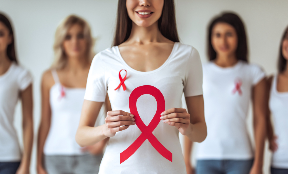 group of young multiracial woman with red ribbons are struggling against HIV/AIDS. AIDS awareness concept