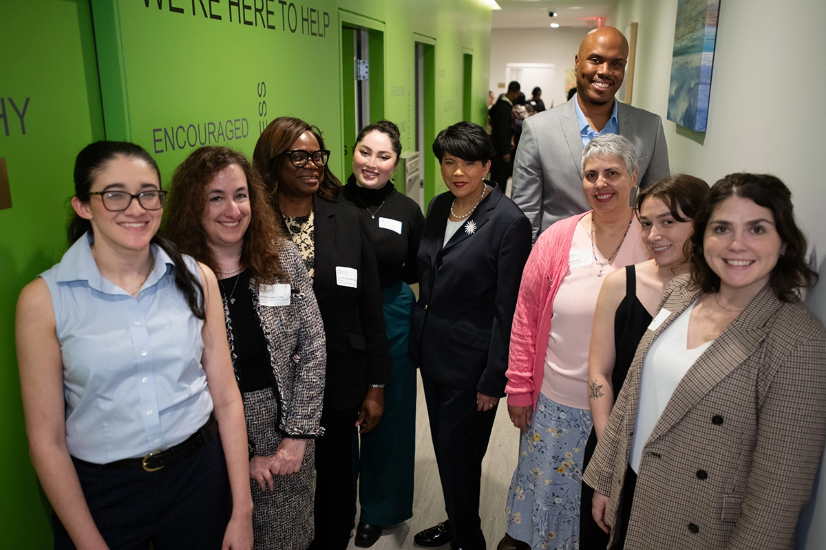 A group of Community Counseling and Mediation employees stand and pose for a photo together